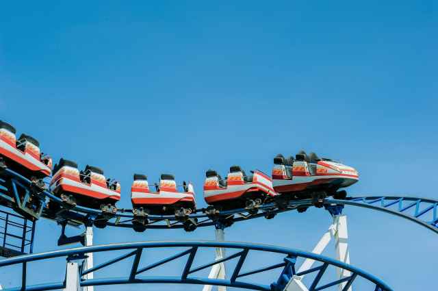 red and white roller coaster on railings